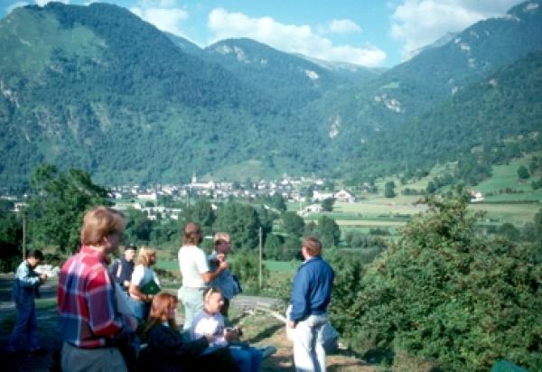 Students sitting in valley, surrounded by mountains