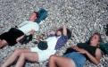 Three students laying on rocks in sun