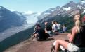Students sitting hillside surrounded by mountains