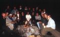 Night group shot of class sitting by a fire