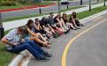 Row of students sitting curbside