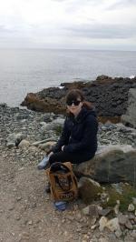 Katherine sitting on rocks by water